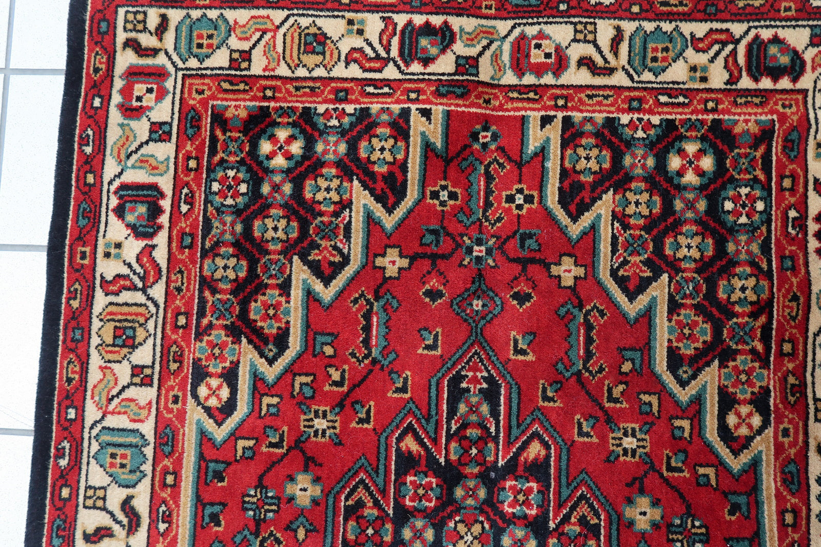 Vintage rug made in Persian Mazlahan design. The rug is in bright color of red. It is from the end of 20th century in original good condition. The rug is machine made.