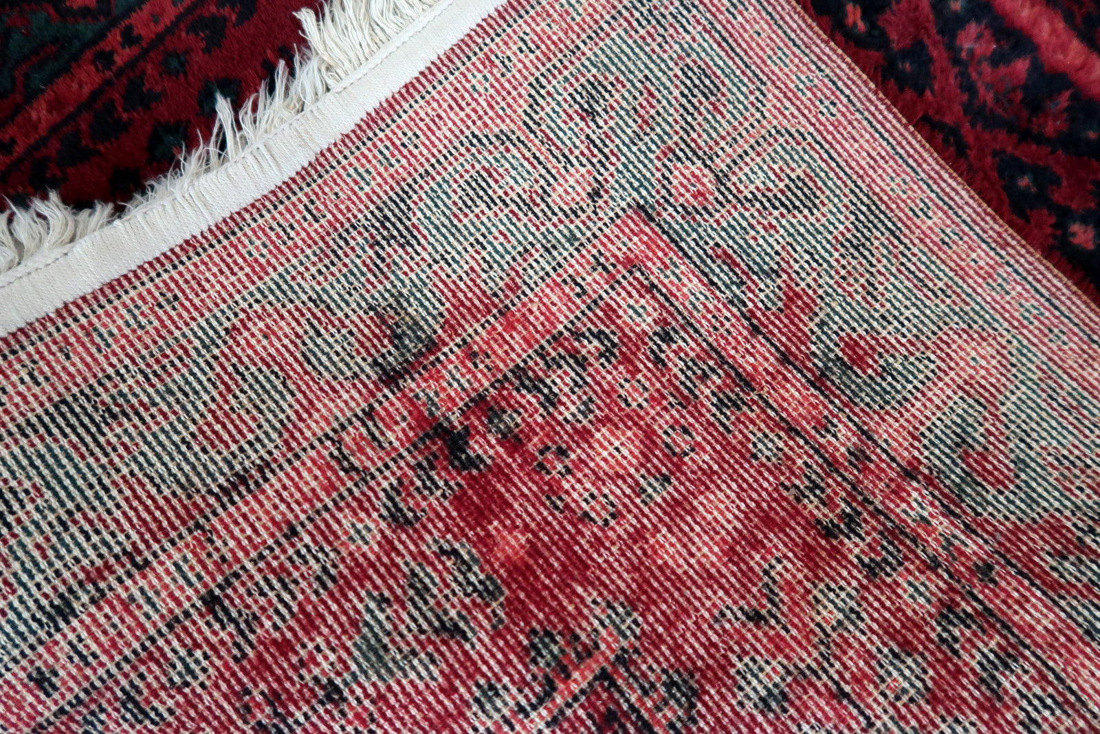 Vintage red woolen rug from Germany made in Baluch style. The rug is in deep red and emerald shades. It is from the middle of 20th century in original good condition.
