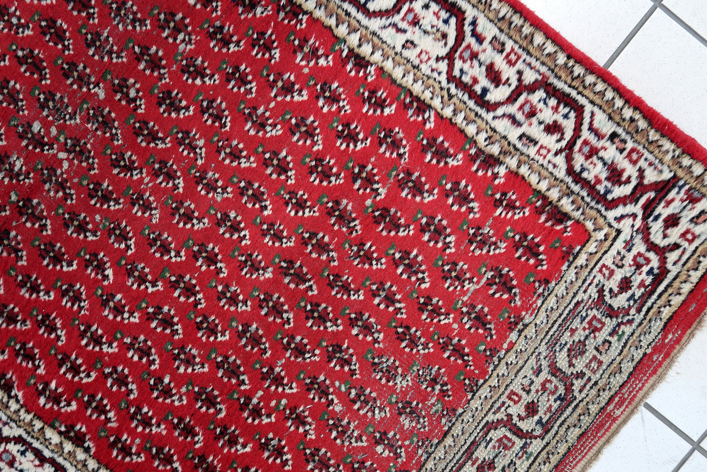Handmade vintage Indian Seraband rug in red color and all-over design. The rug has been made in the end of 20th century. It is in original condition, has some low pile.