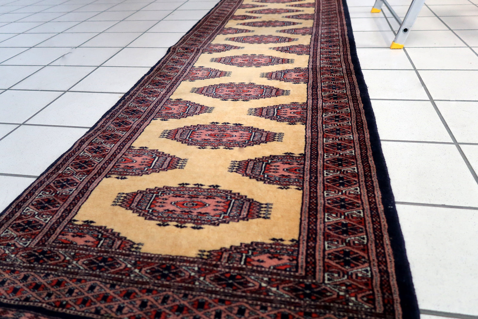 Handmade vintage Uzbek Bukhara narrow runner in yellow wool. The rug has traditional design. It is from the end of 20th century, in original good condition.