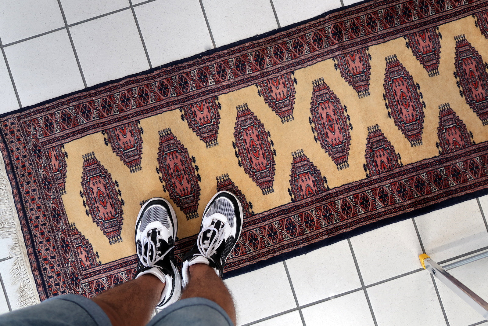 Handmade vintage Uzbek Bukhara narrow runner in yellow wool. The rug has traditional design. It is from the end of 20th century, in original good condition.