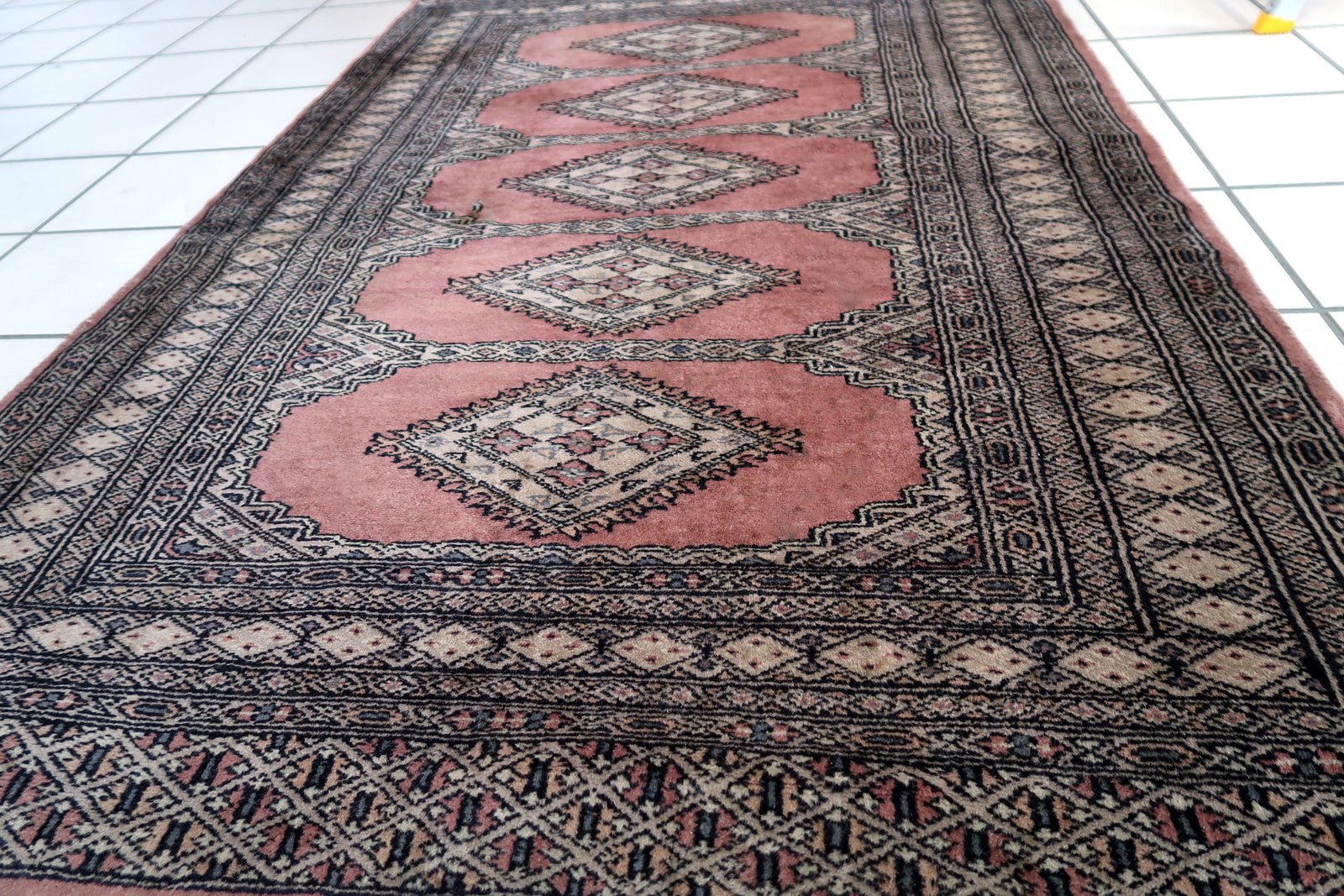 Handmade vintage Uzbek Bukhara rug in traditional design and pink wool. The rug is from the end of 20th century. It is in original good condition.