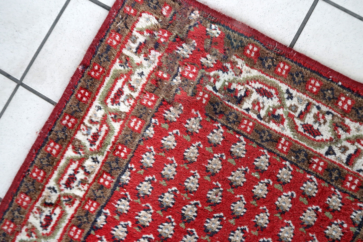 Handmade vintage Indian Seraband rug in red color and all-over design. The rug has been made in the end of 20th century. It is in good condition, has some signs of age.