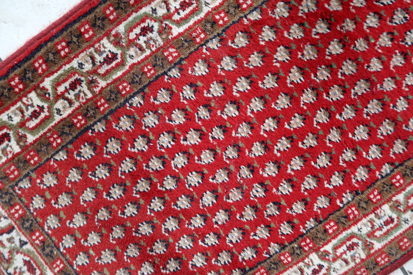 Handmade vintage Indian Seraband rug in red color and all-over design. The rug has been made in the end of 20th century. It is in good condition, has some signs of age.