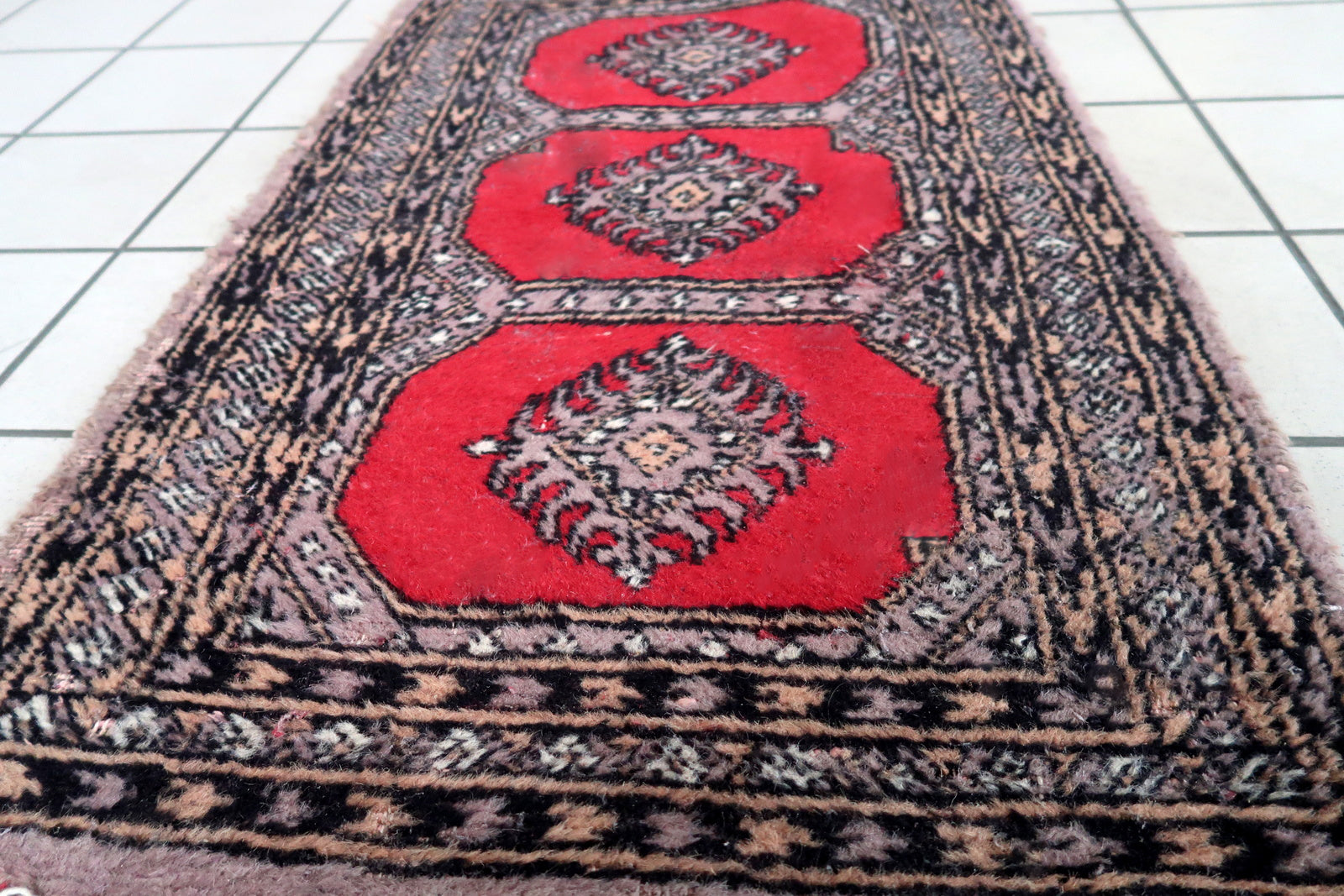 Handmade vintage Uzbek Bukhara rug in traditional design. The rug is from the end of 20th century, it is in original condition, has some signs of age.