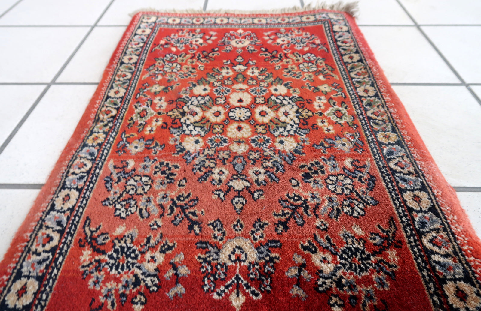 Vintage red German rug in traditional Persian Sarouk design. The rug has been made in the end of 20th century, it is in original good condition. The rug is machine made.