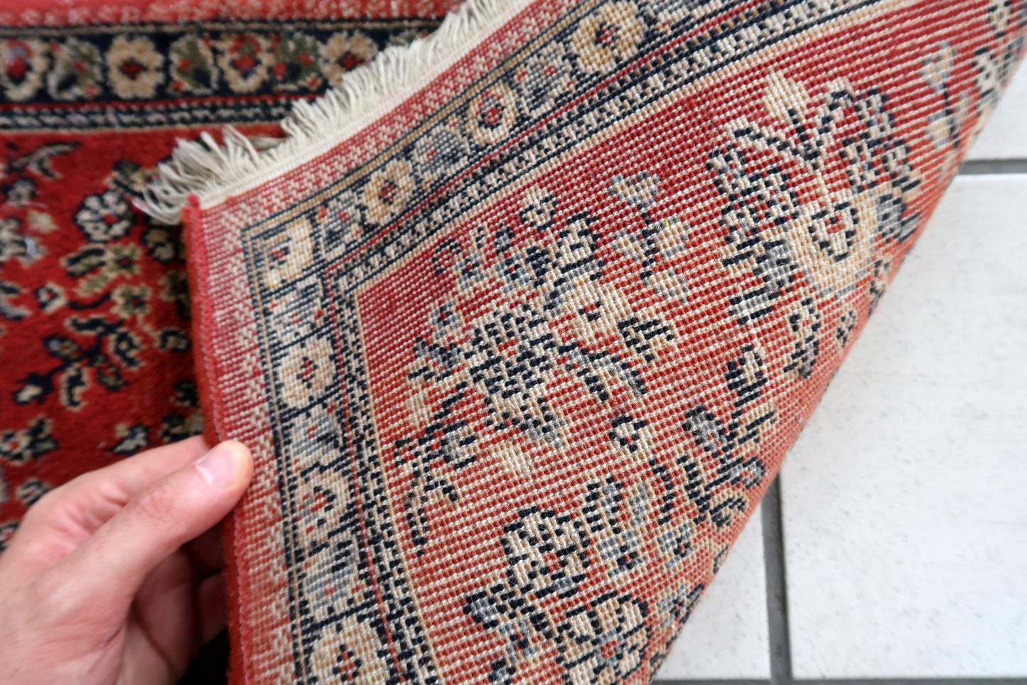 Vintage red German rug in traditional Persian Sarouk design. The rug has been made in the end of 20th century, it is in original good condition. The rug is machine made.