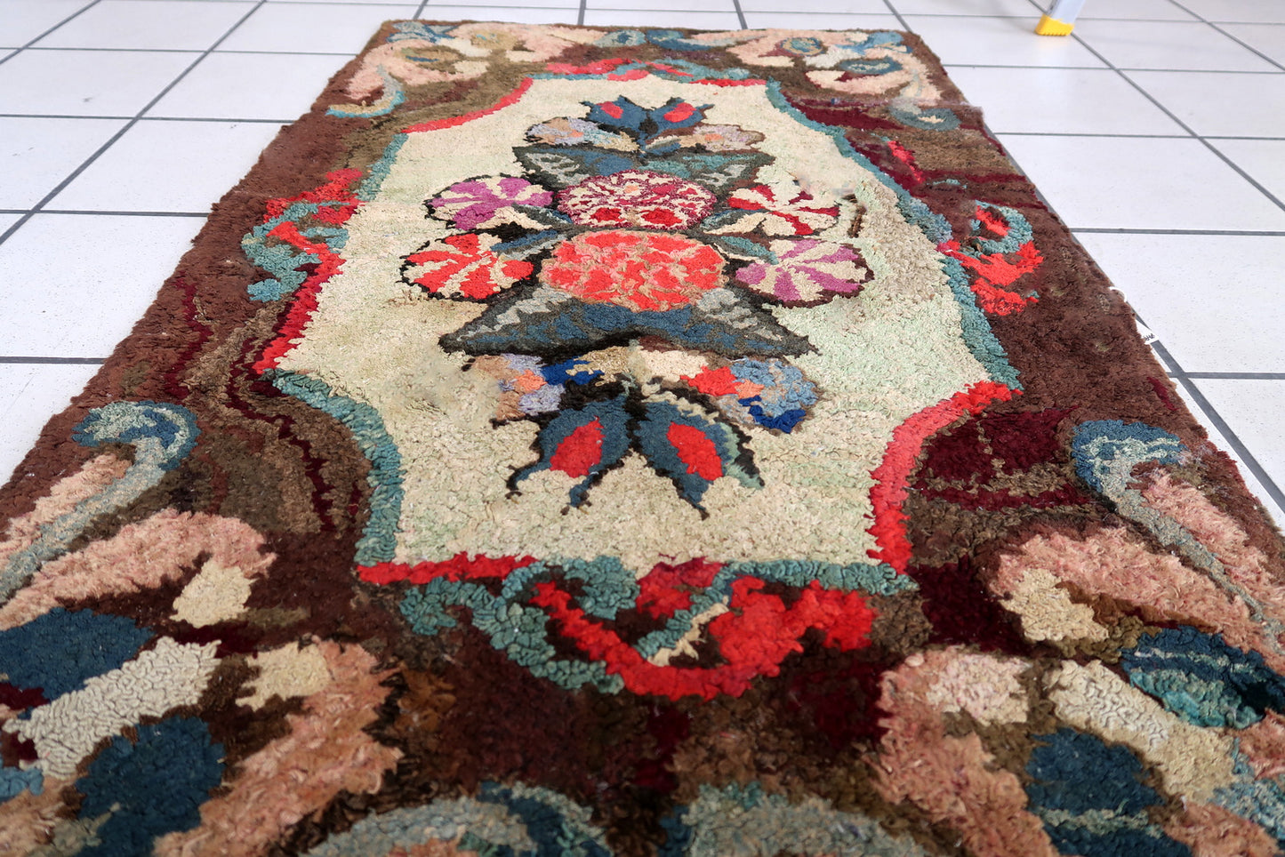 Handmade antique American Hooked rug in floral design. The rug is from the end of 19th century. It is in good condition, has some old restorations.