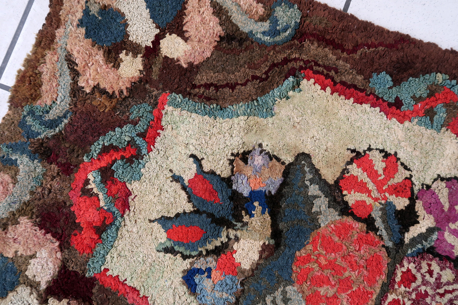 Handmade antique American Hooked rug in floral design. The rug is from the end of 19th century. It is in good condition, has some old restorations.