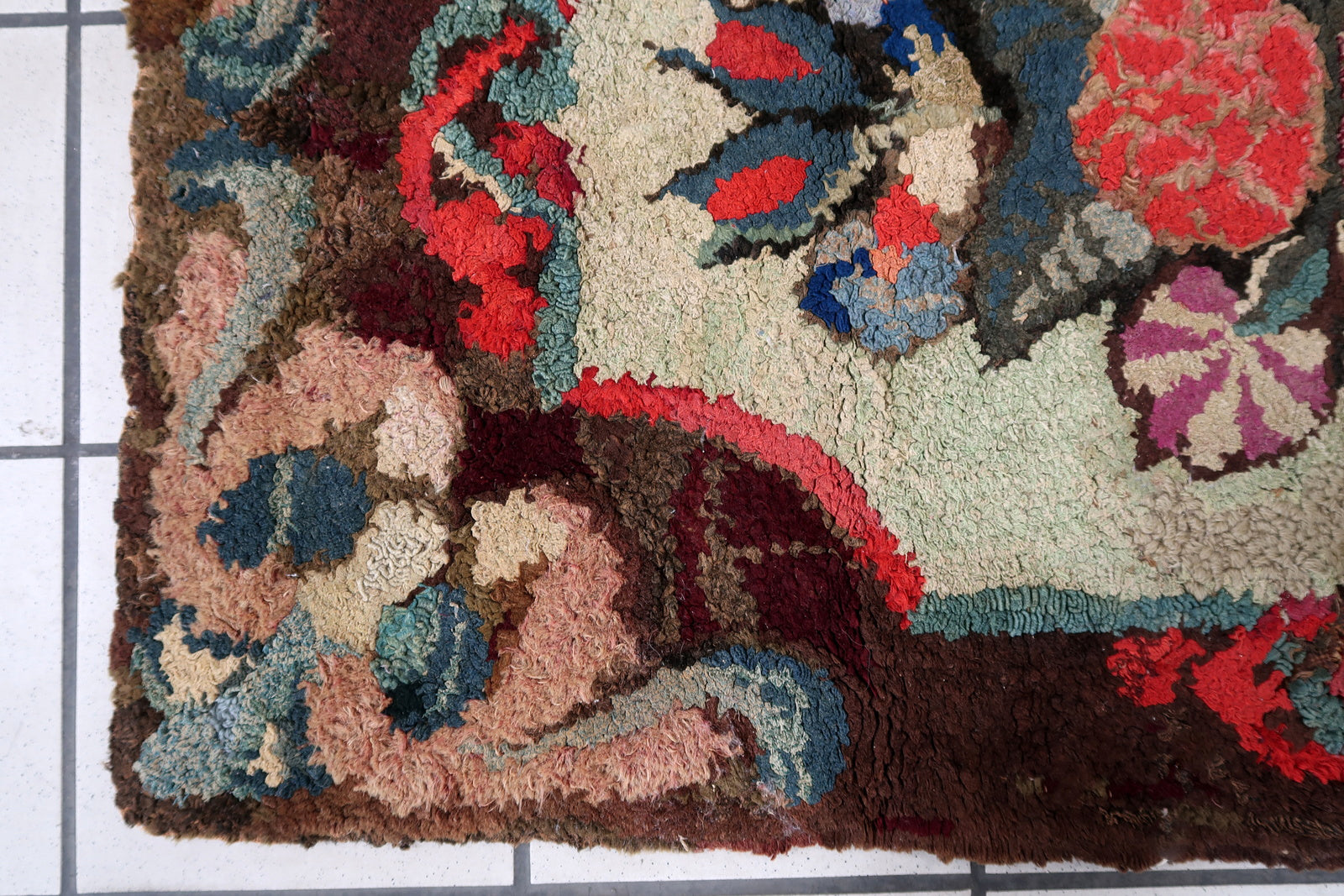 Handmade antique American Hooked rug in floral design. The rug is from the end of 19th century. It is in good condition, has some old restorations.