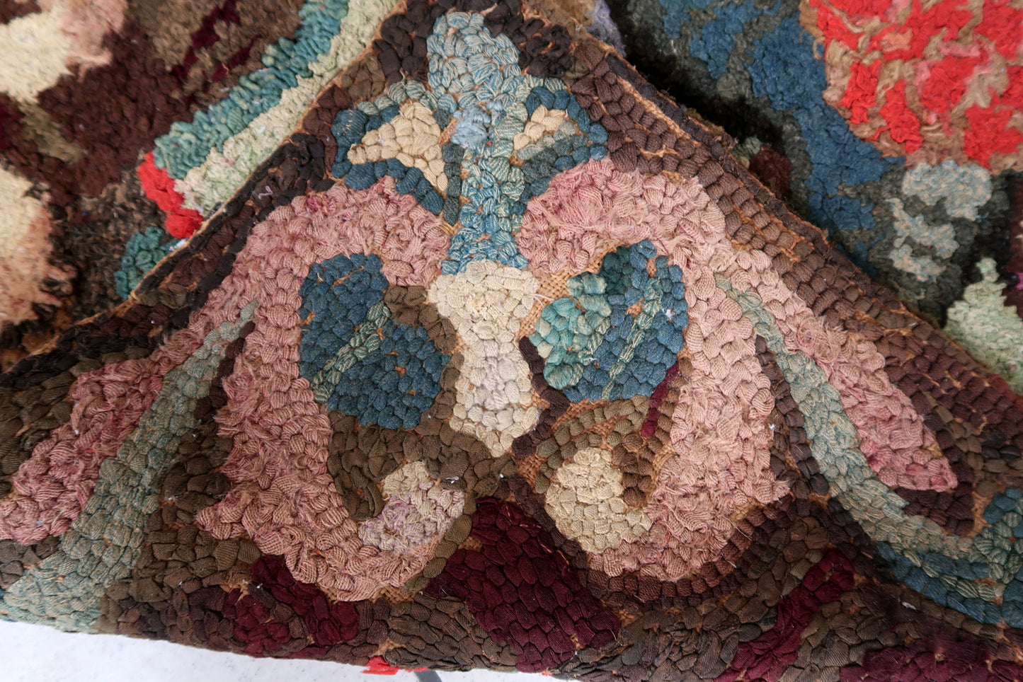Handmade antique American Hooked rug in floral design. The rug is from the end of 19th century. It is in good condition, has some old restorations.