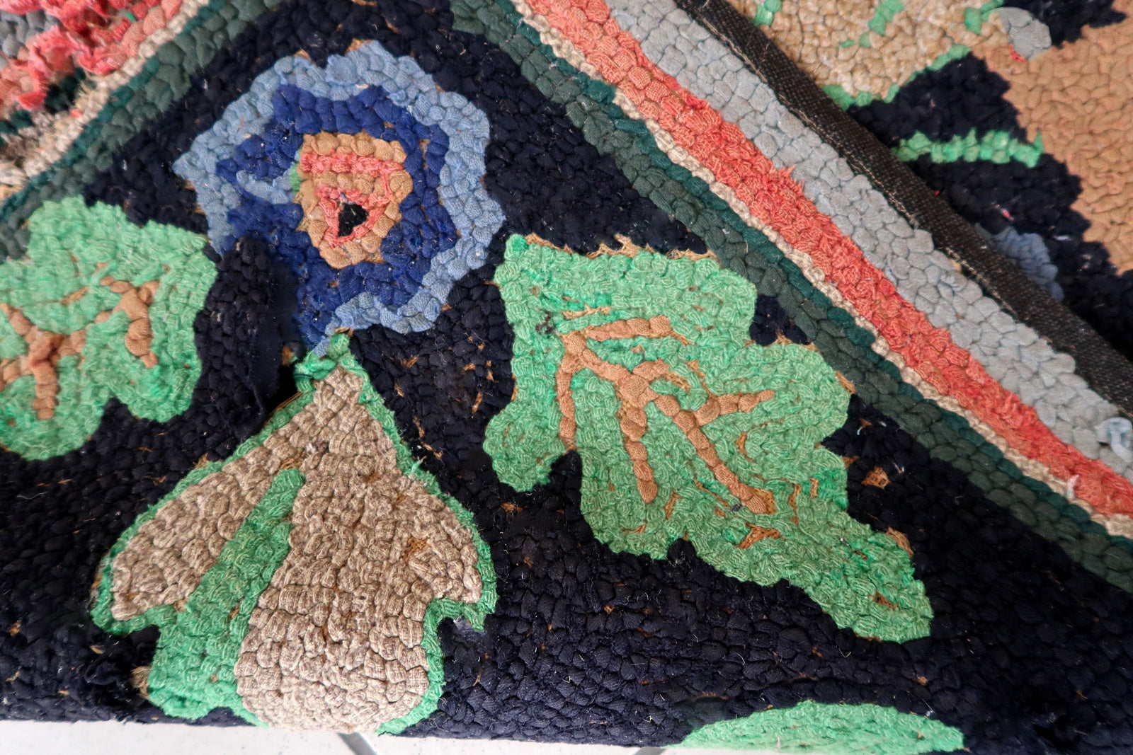 Handmade antique American Hooked rug in floral design and black background. The rug is from the beginning of 20th century. It is in good condition, has some old restorations. 