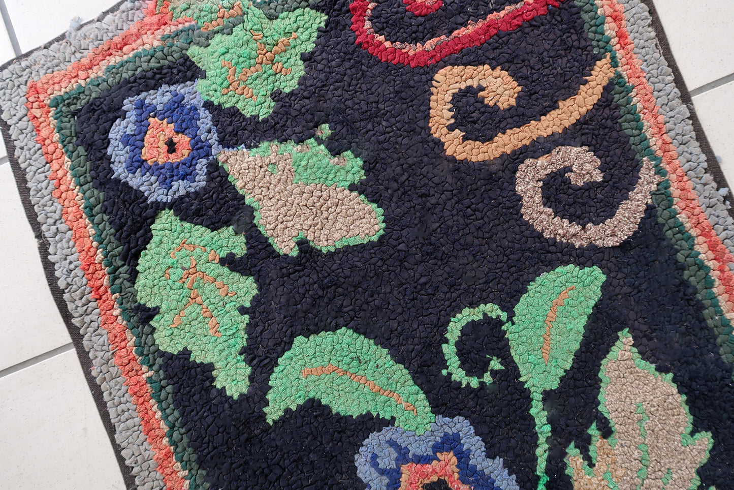 Handmade antique American Hooked rug in floral design and black background. The rug is from the beginning of 20th century. It is in good condition, has some old restorations. 