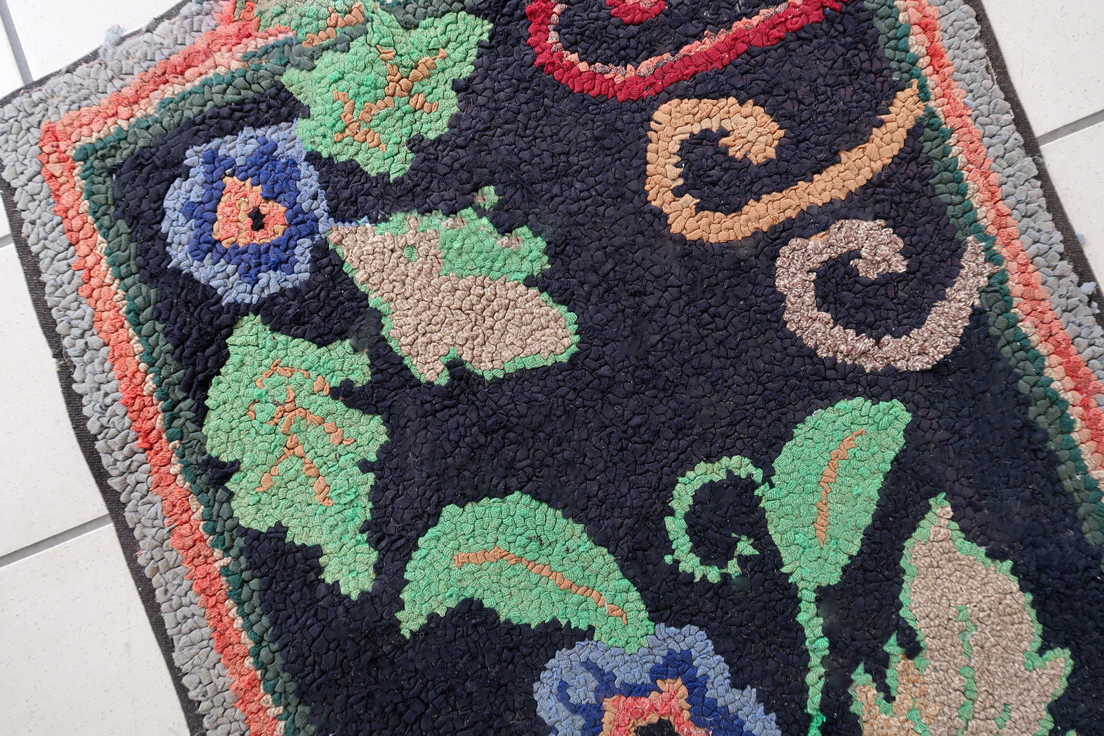 Handmade antique American Hooked rug in floral design and black background. The rug is from the beginning of 20th century. It is in good condition, has some old restorations. 