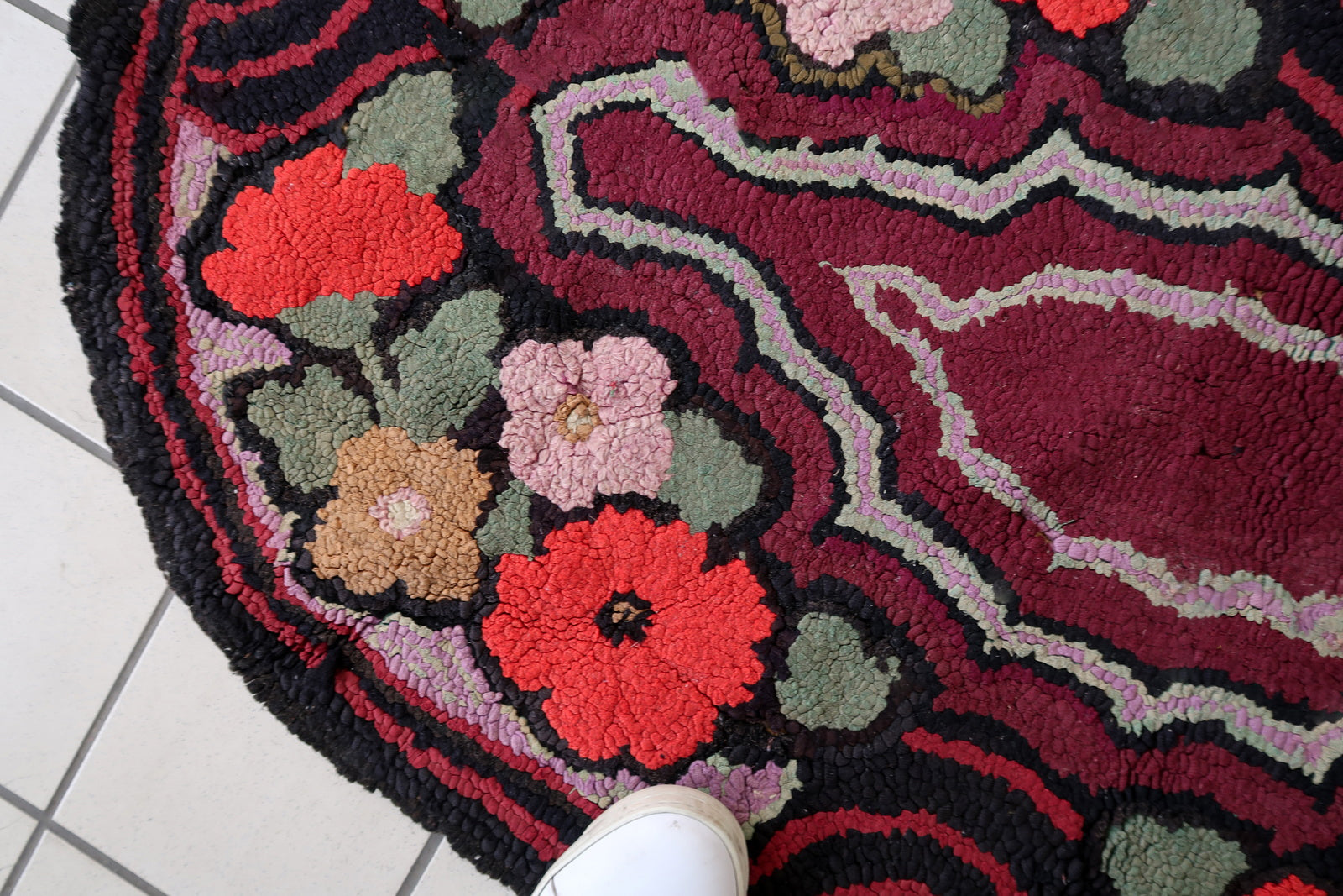 Handmade antique American Hooked rug in floral design and black background. The rug is from the beginning of 20th century. It is in good condition, has some old restorations. 