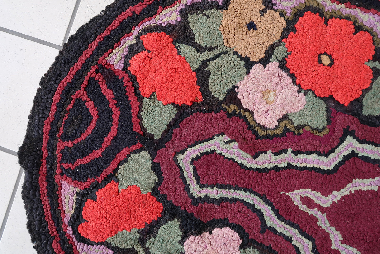 Handmade antique American Hooked rug in floral design and black background. The rug is from the beginning of 20th century. It is in good condition, has some old restorations. 