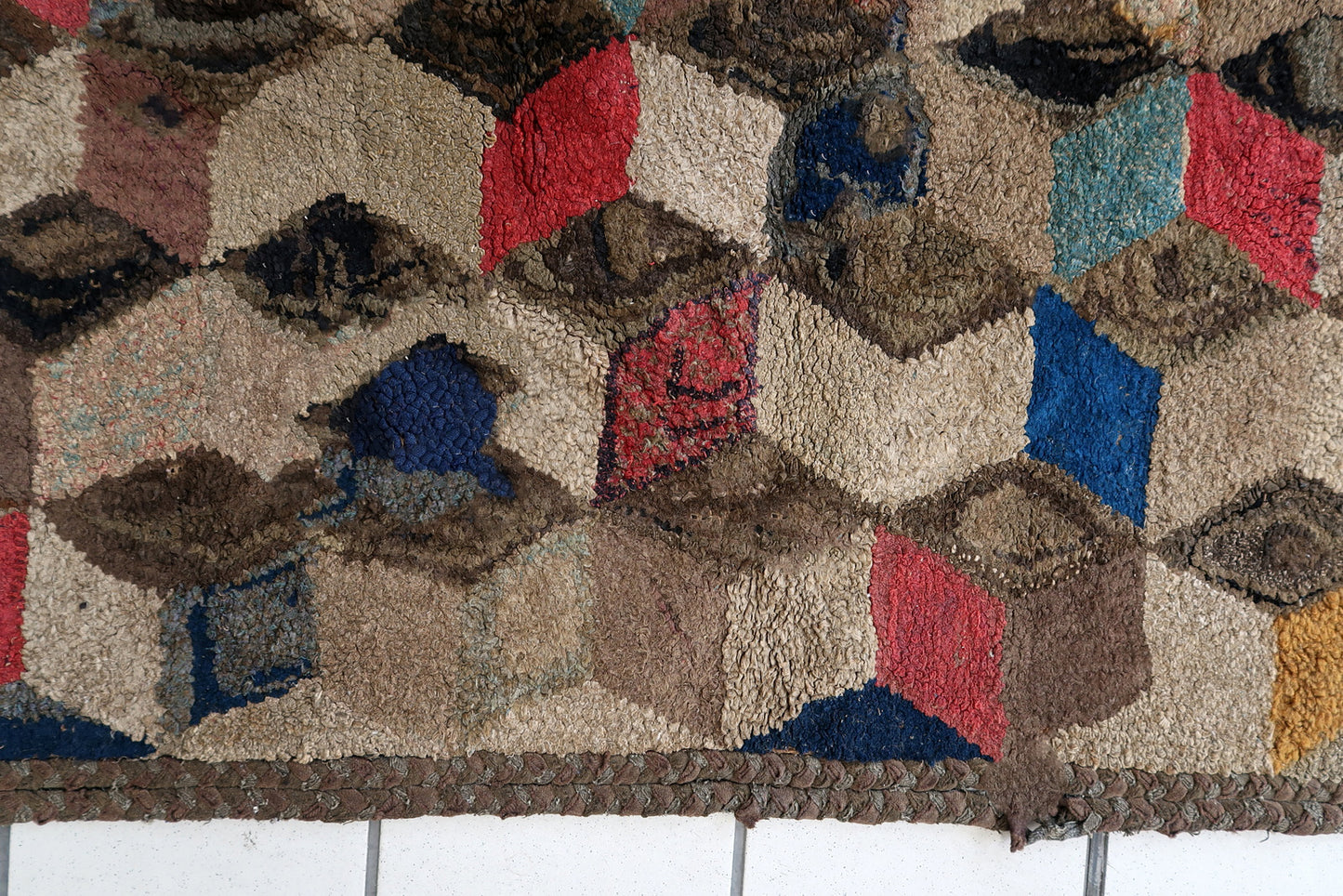 Handmade antique American Hooked rug in geometric design. The rug is from the end of 19th century. The rug has some old restorations. 