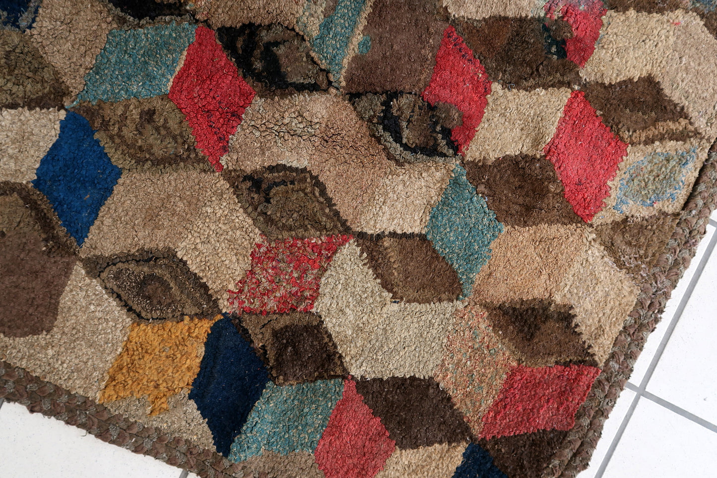 Handmade antique American Hooked rug in geometric design. The rug is from the end of 19th century. The rug has some old restorations. 