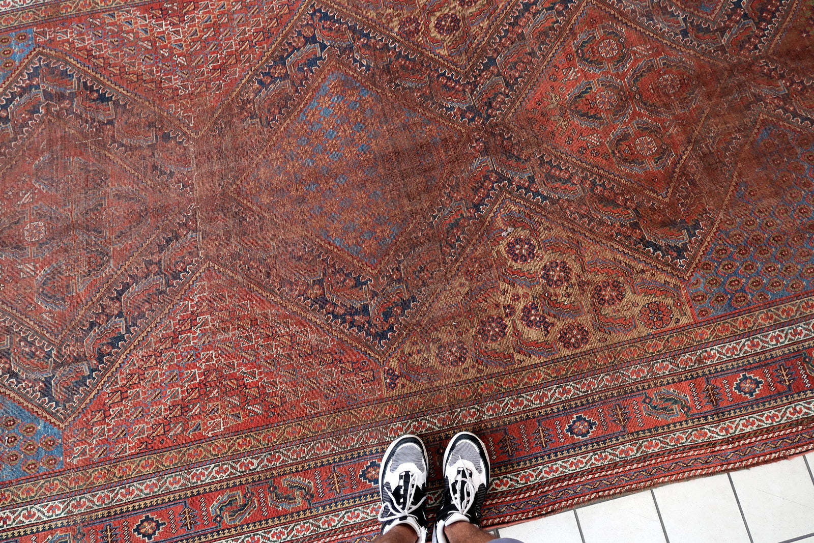 Handmade antique oversized Persian Khamseh rug in traditional design. The rug is from the end of 19th century in distressed condition. 