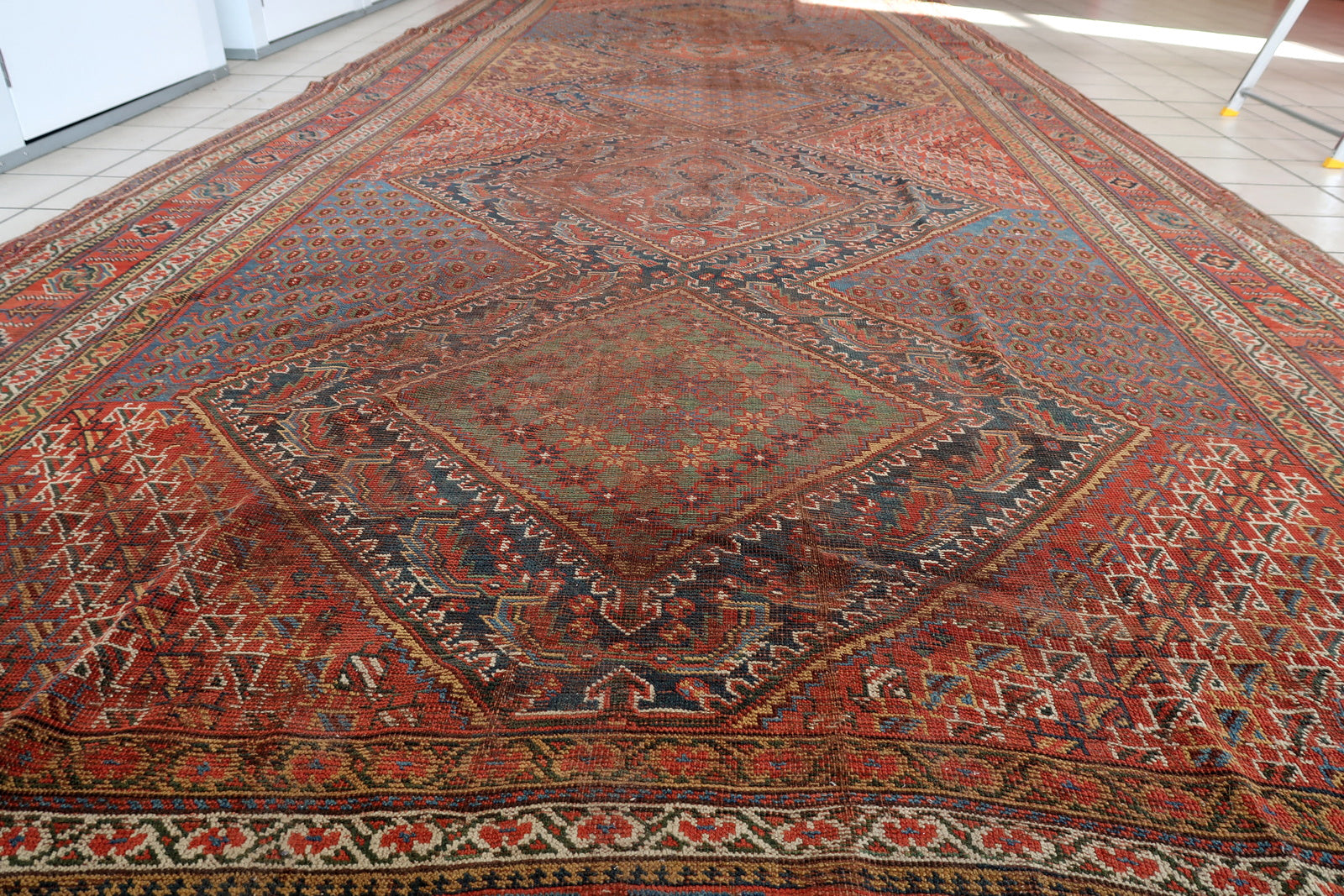 Handmade antique oversized Persian Khamseh rug in traditional design. The rug is from the end of 19th century in distressed condition. 