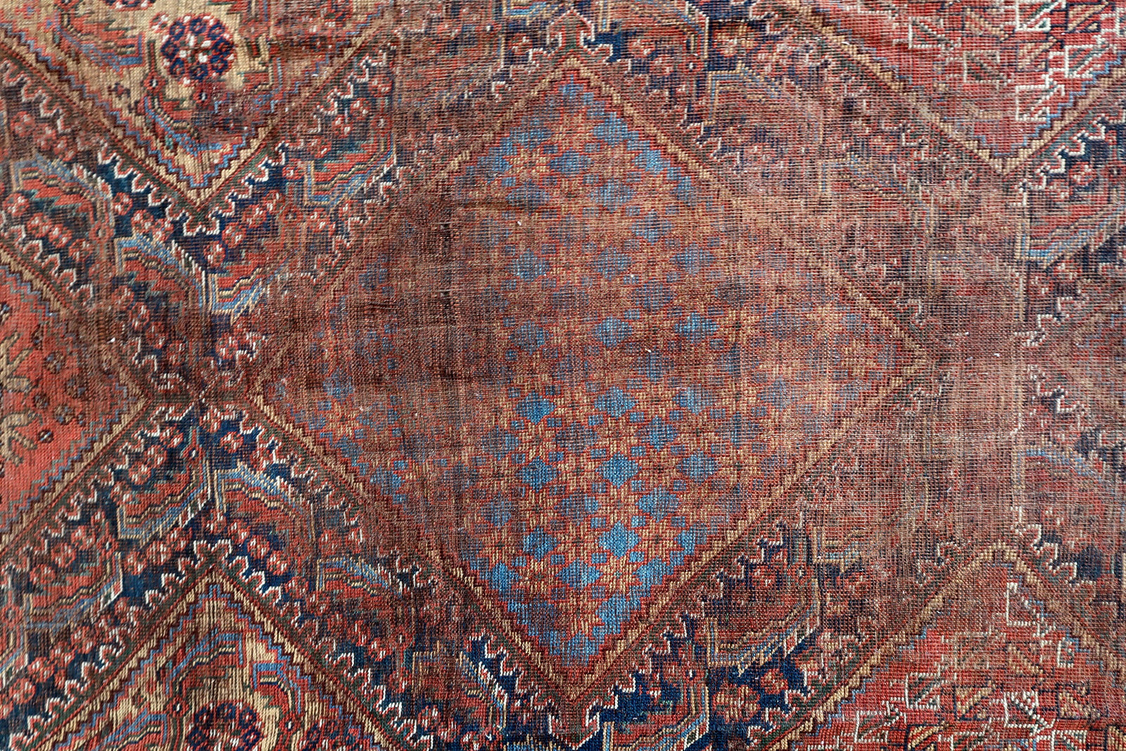 Handmade antique oversized Persian Khamseh rug in traditional design. The rug is from the end of 19th century in distressed condition. 