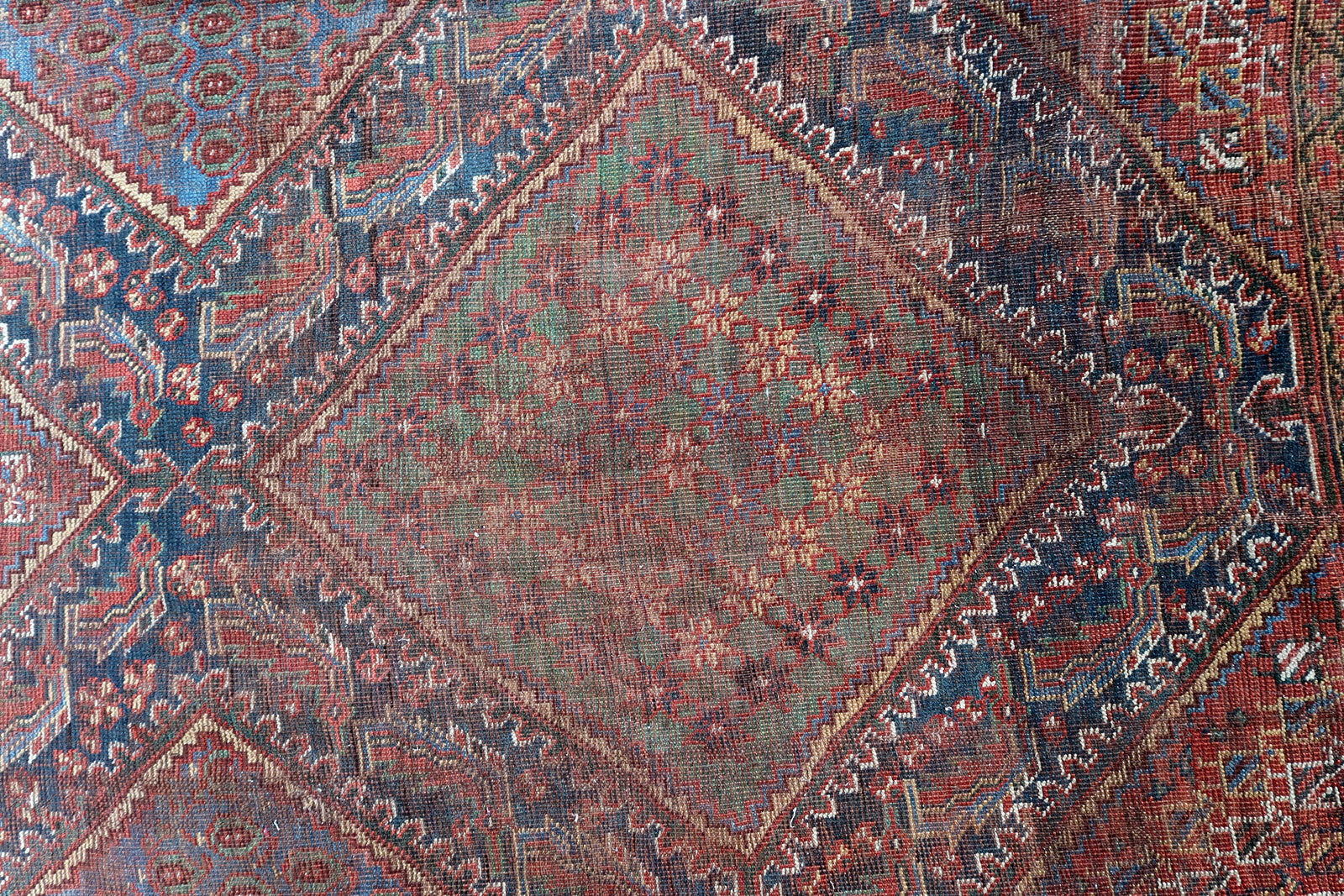 Handmade antique oversized Persian Khamseh rug in traditional design. The rug is from the end of 19th century in distressed condition. 