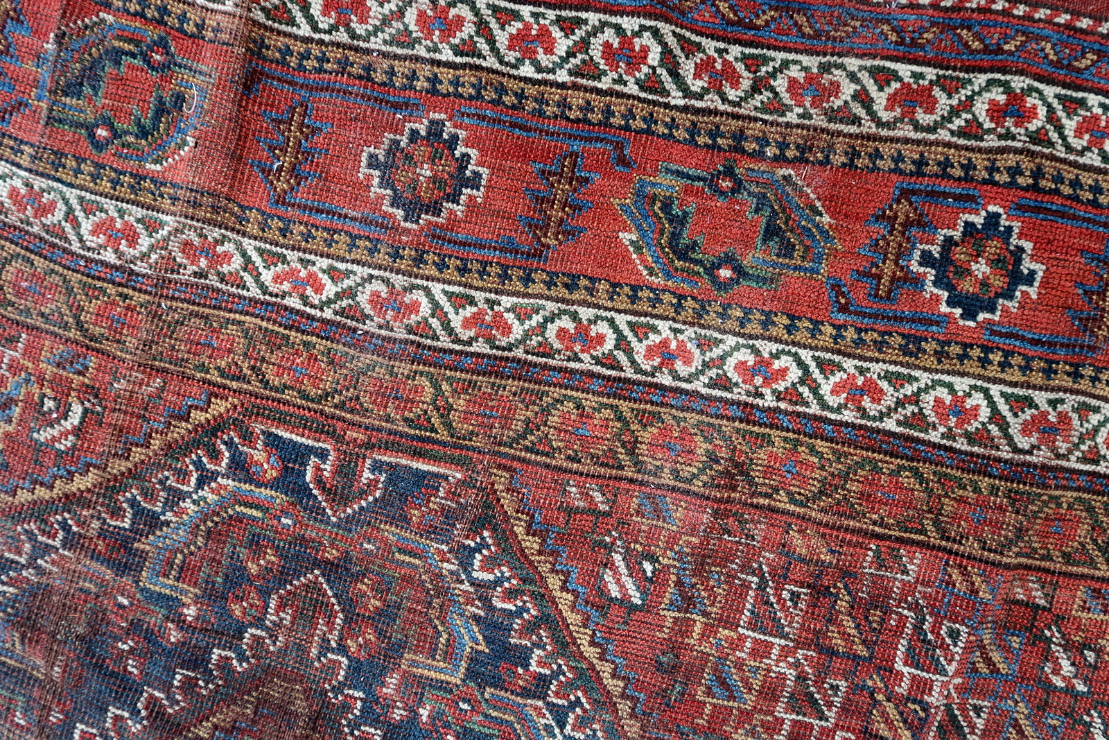 Handmade antique oversized Persian Khamseh rug in traditional design. The rug is from the end of 19th century in distressed condition. 