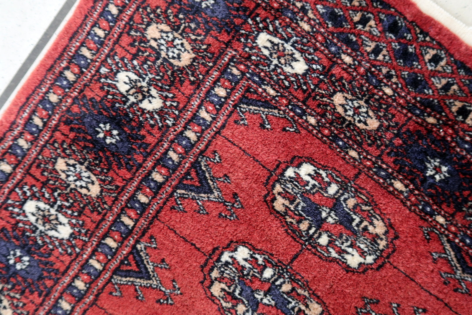 Handmade vintage red rug in Bukhara design. The rug is in original good condition, from the end of 20th century.