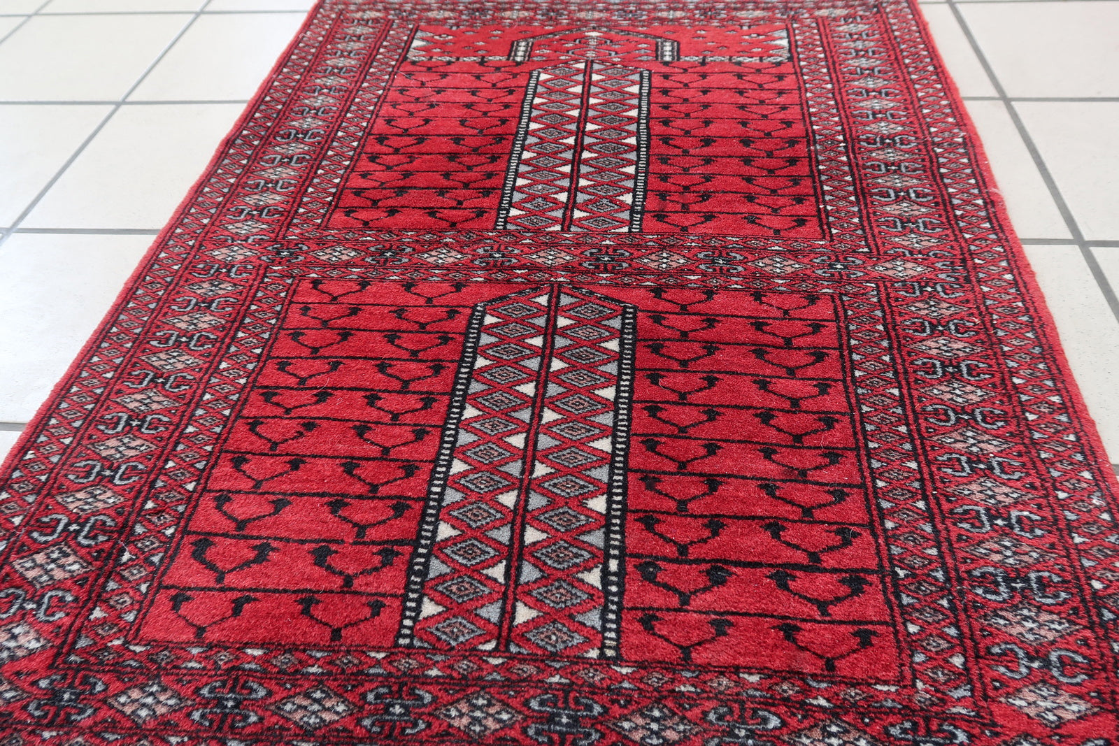 Handmade vintage red prayer rug from Pakistan in Lahore style. The rug is in original good condition, it is from the end of 20th century.