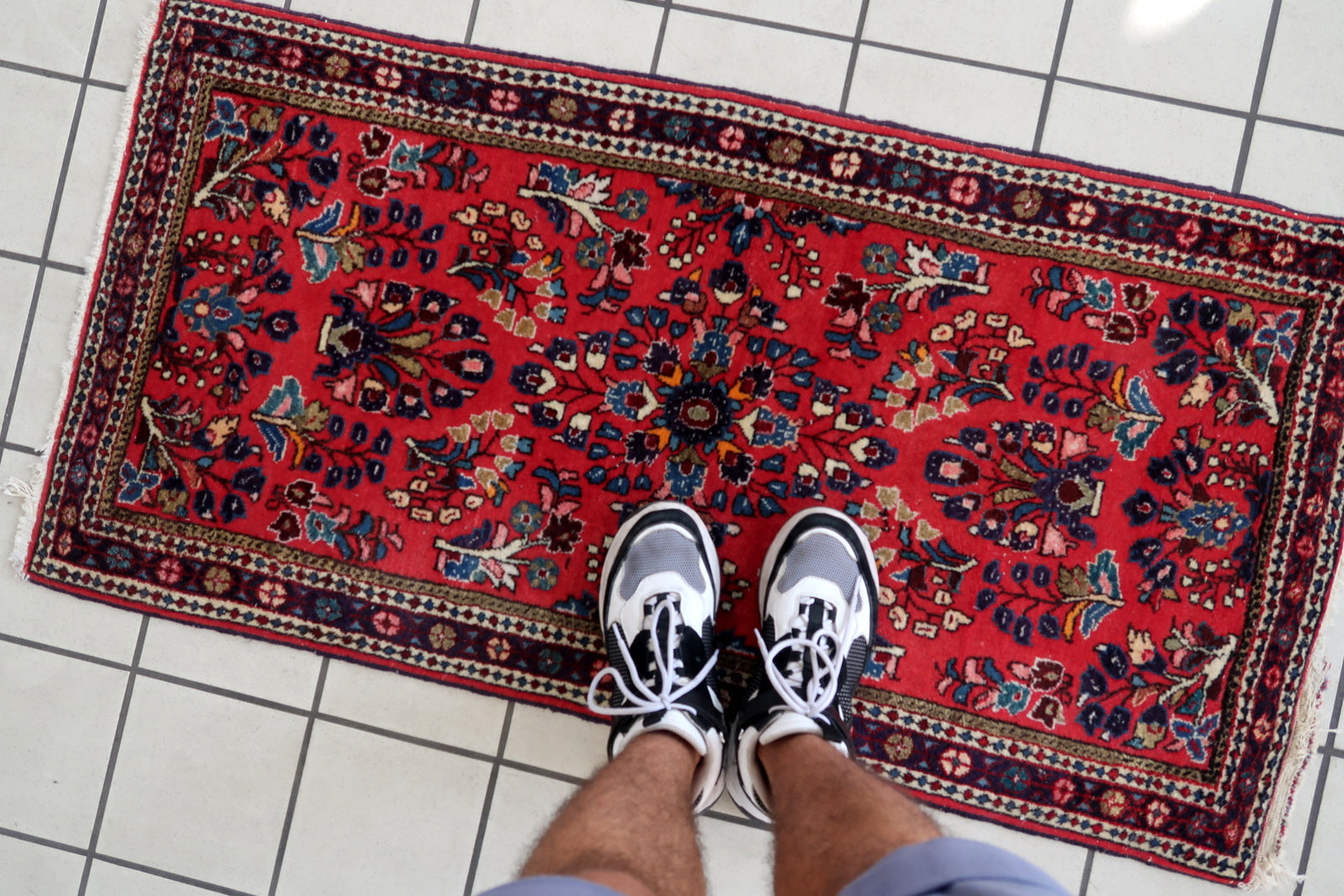 Handmade vintage Sarouk rug in traditional design. The rug is in red color. The rug is from the end of 20th century in original good condition.