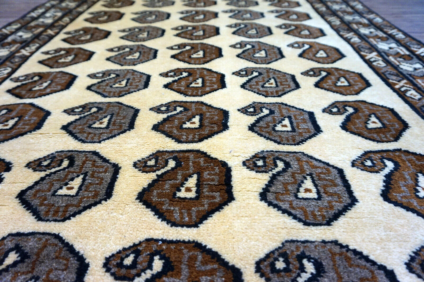 Handmade vintage Persian Gabbeh rug in beige color with repeating paisley design. The rug is from the end of 20th century in original good condition.
