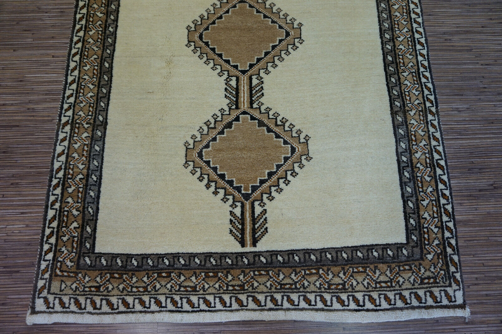 Handmade vintage Persian Gabbeh rug in beige color and repeating geometric design. The rug is from the end of 20th century in original good condition.