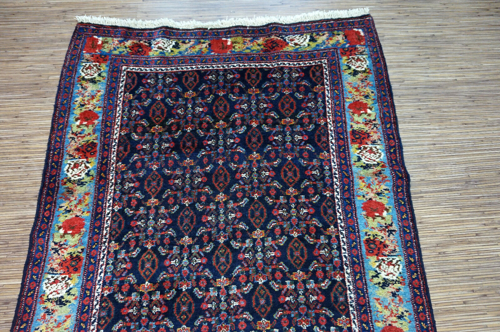 Handmade antique Persian Senneh runner in  deep shade of blue with repeating pattern. The rug is from the beginning of 20th century in original good condition.