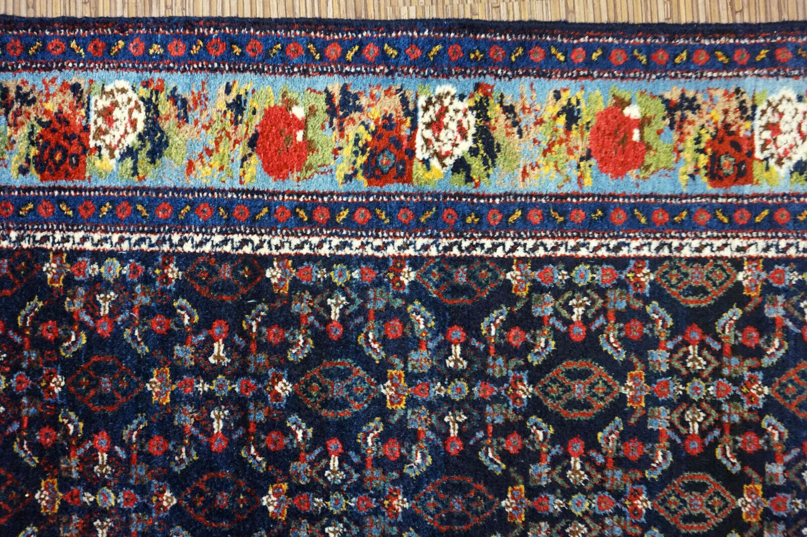 Handmade antique Persian Senneh runner in  deep shade of blue with repeating pattern. The rug is from the beginning of 20th century in original good condition.