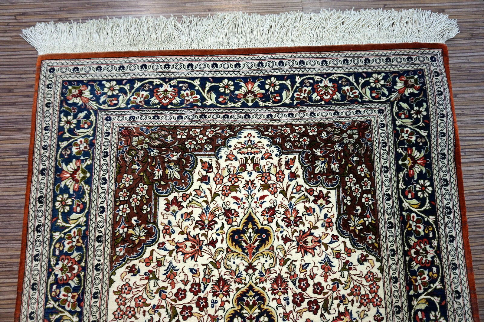 Handmade vintage Persian Qum rug in very busy floral design with natural colors. The rug has been made in silk. It is is from the end of 20th century in original good condition.