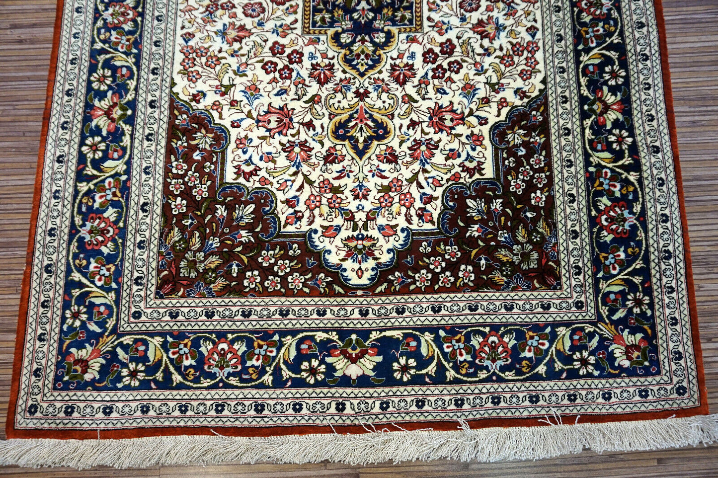 Handmade vintage Persian Qum rug in very busy floral design with natural colors. The rug has been made in silk. It is is from the end of 20th century in original good condition.