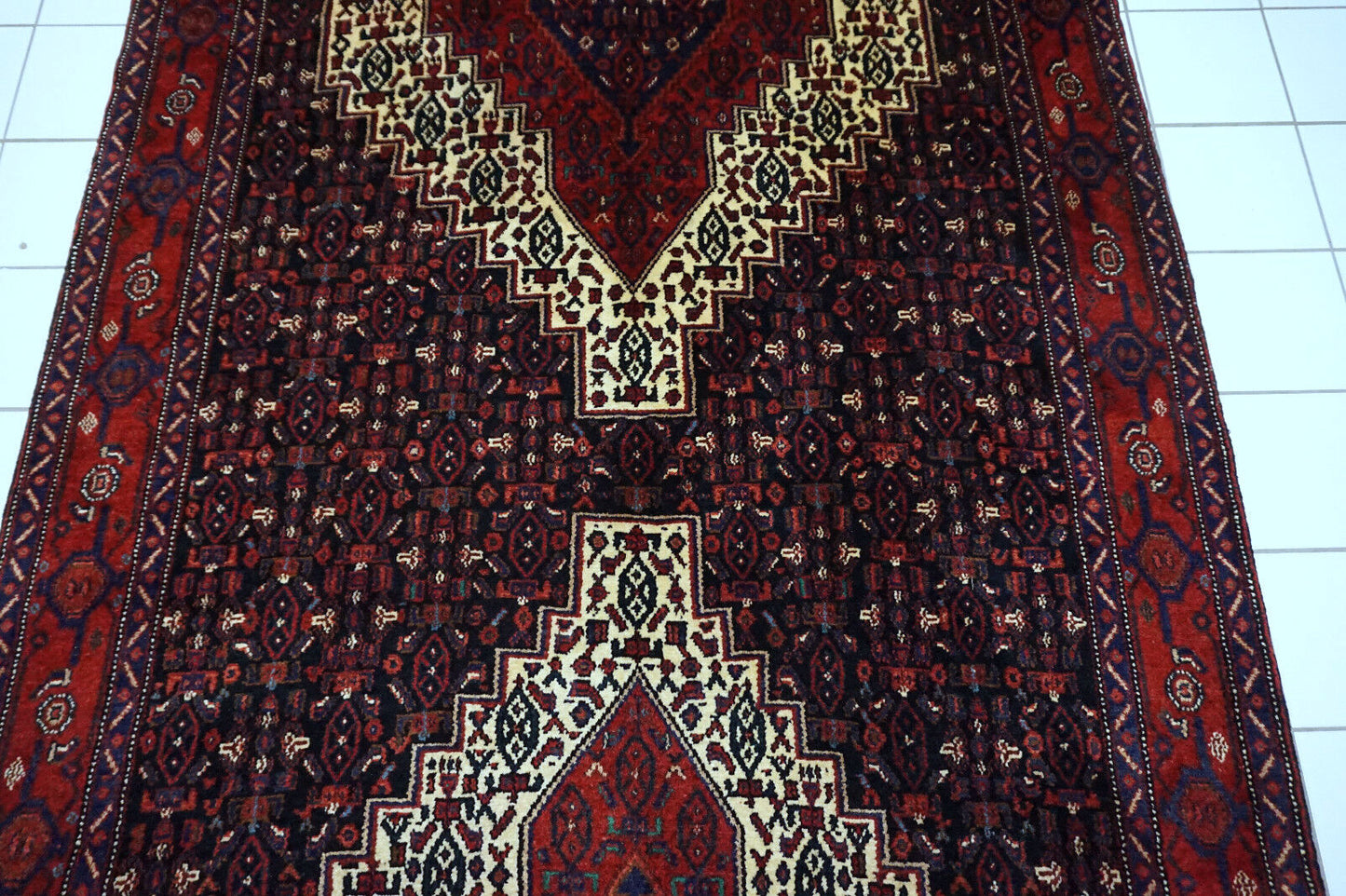 Handmade vintage Persian Senneh rug in kele size and traditional design. The rug is from the end of 20th century in original good condition.