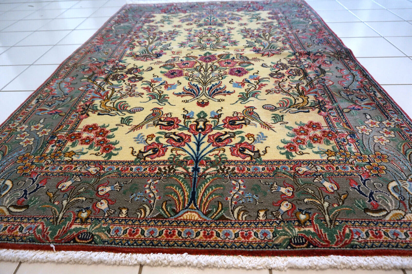 Close-up of the colorful flowers and birds design on the vintage Qum rug.
