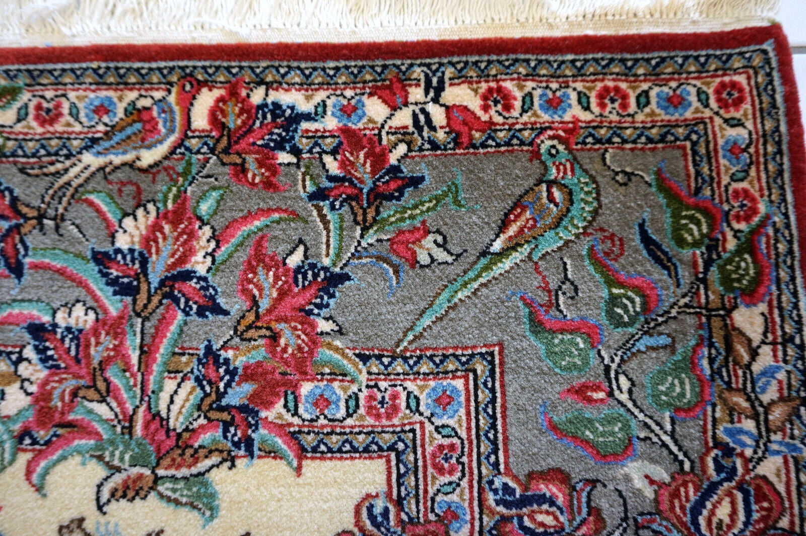 A corner of the vintage Qum rug showing the intricate weaving and detail.