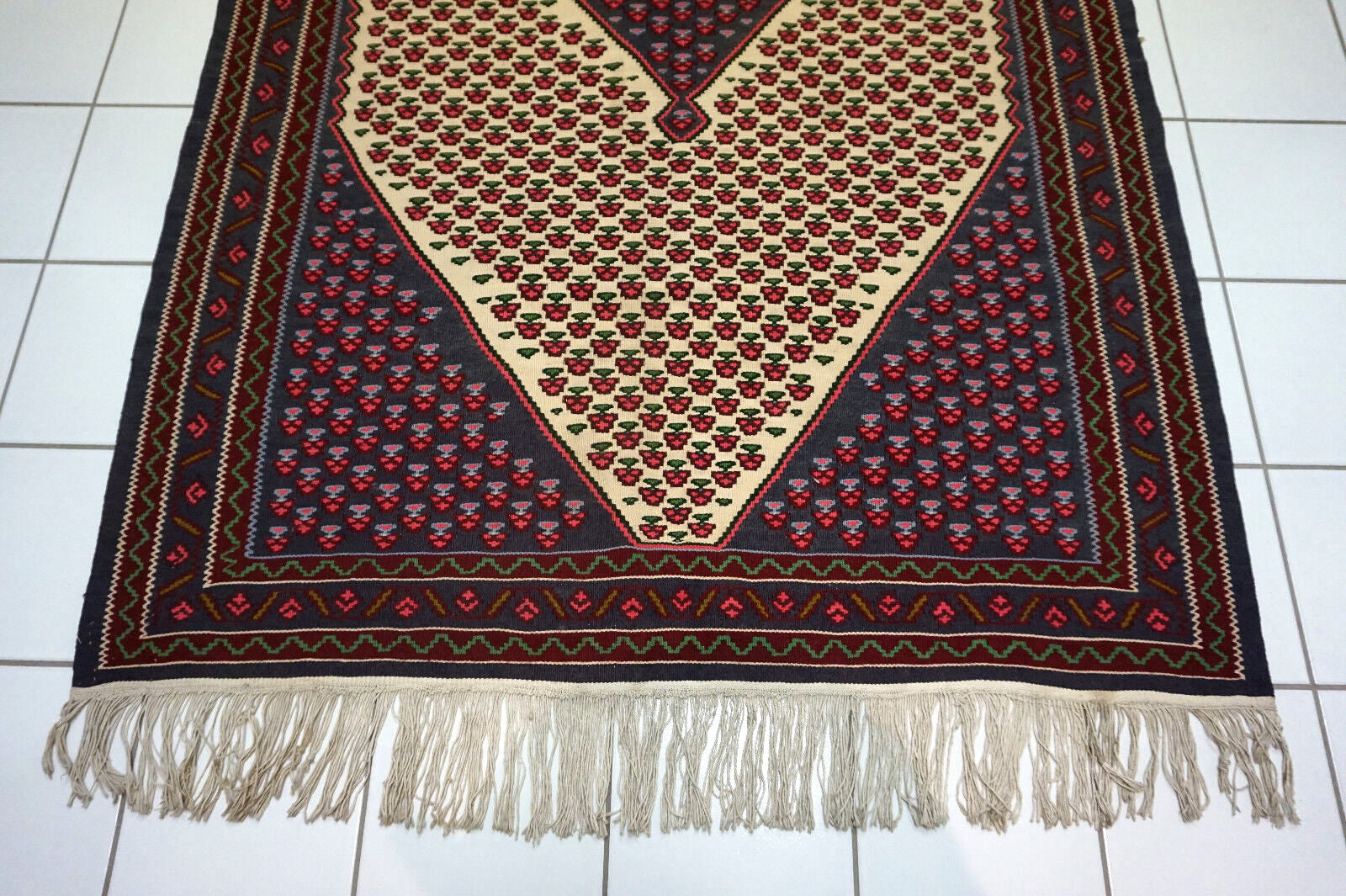Close-up of the beige, pink, green, burgundy, and blue colors in the kilim