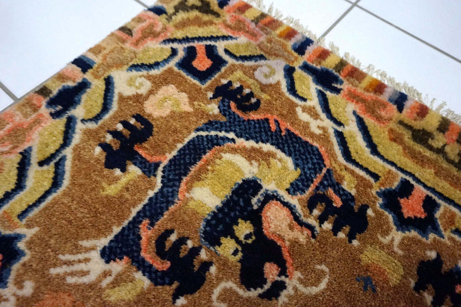 Detailed view of navy blue dragons on antique Chinese rug