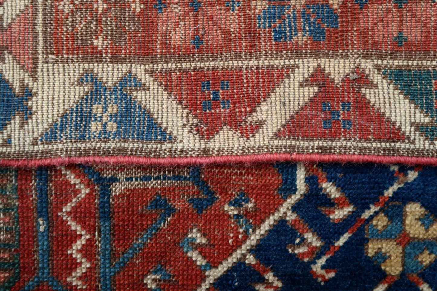 Handmade antique rug from Caucasian Shirvan region in blue and red colors. The rug has two different blues on the background. The rug is from the end of 19th century in distressed condition, it has some low pile and old restorations.