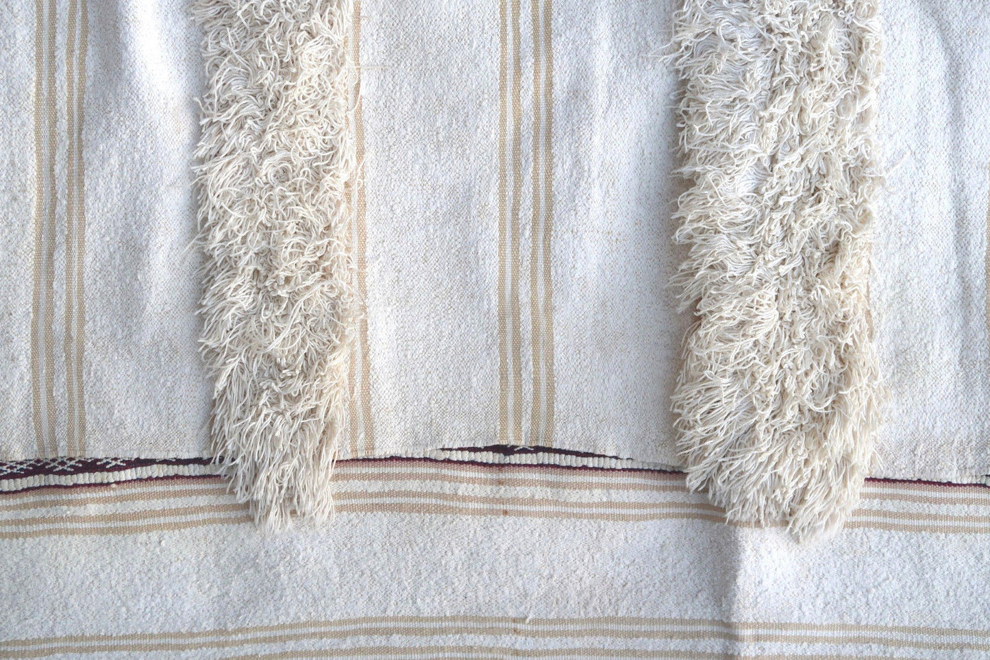 Handmade vintage Moroccan woolen kilim in white color with the stripes. This flatweave is from the middle of 20th century in original condition, it has some old repair.
