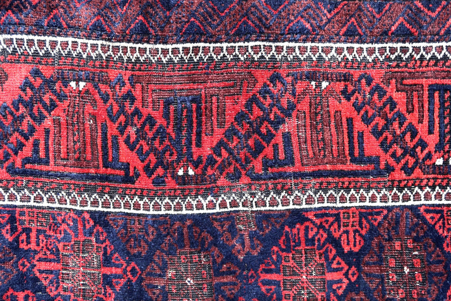 Handmade antique Afghan Baluch rug in all-over design and deep colors. The rug is from the beginning of 20th century in original condition, it has some low pile.