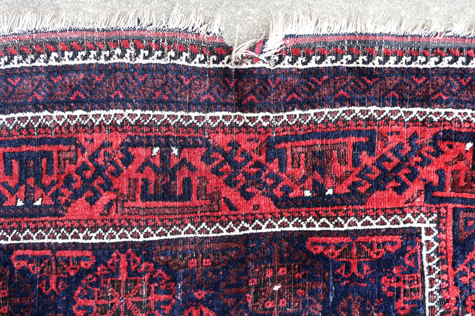 Handmade antique Afghan Baluch rug in all-over design and deep colors. The rug is from the beginning of 20th century in original condition, it has some low pile.