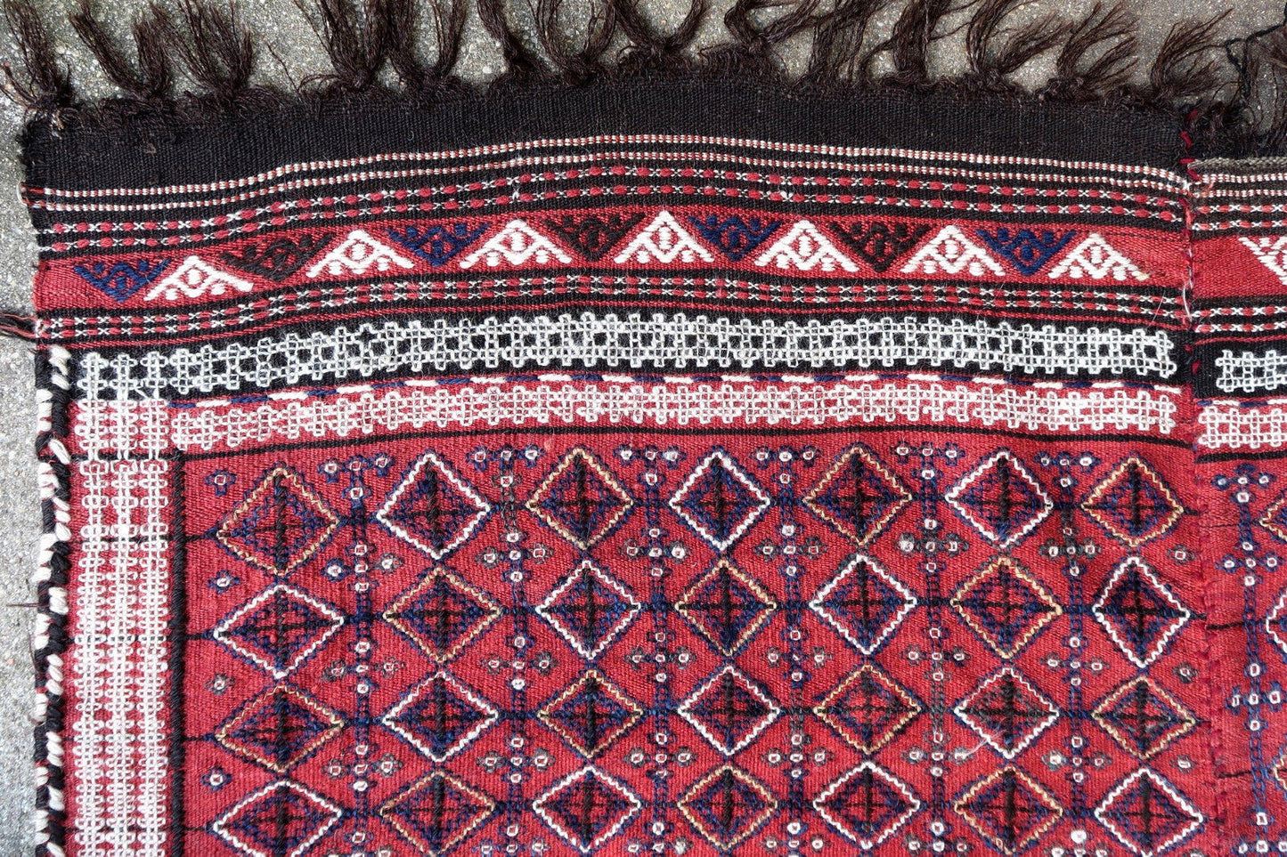Vintage handmade Caucasian Verneh embroidered kilim in geometric design. The rug is from the middle of 20th century made in white, blue and red wool. It has been made in two parts and then stitched together.