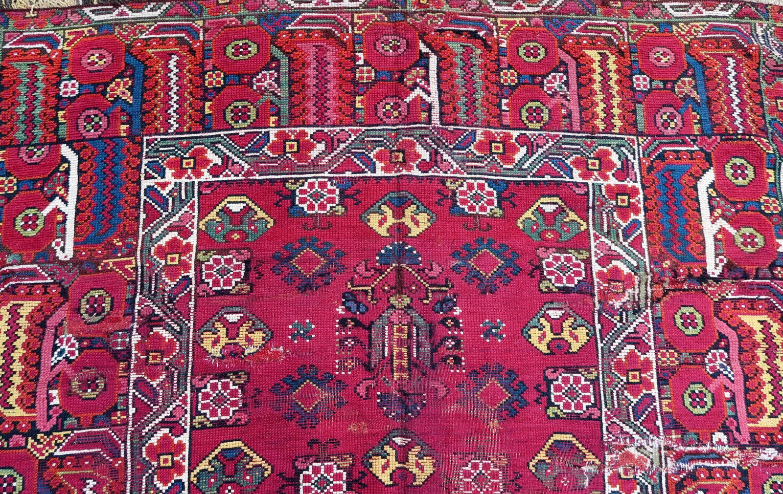 Handmade antique Algerian Berber rug in original condition, it has some signs of age and old restorations. This rug is from the beginning of 19th century made in crimson wool and tribal design.