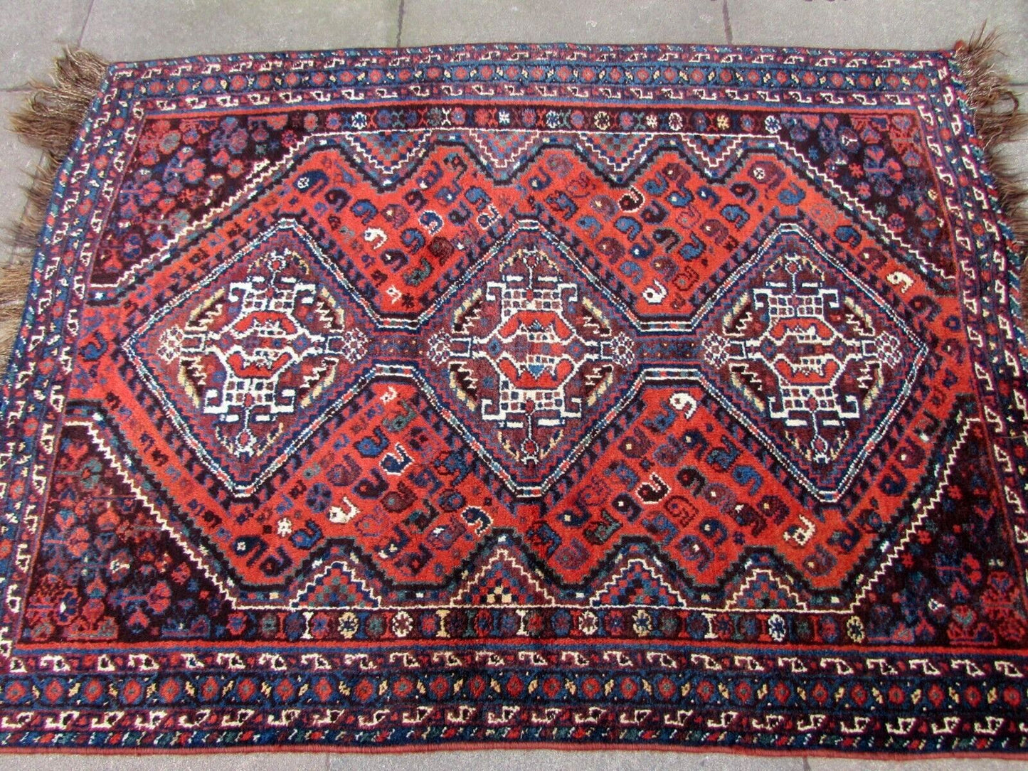 Handmade antique Persian Shiraz rug in traditional medallion design. The rug is from the beginning of 20th century in original good condition.