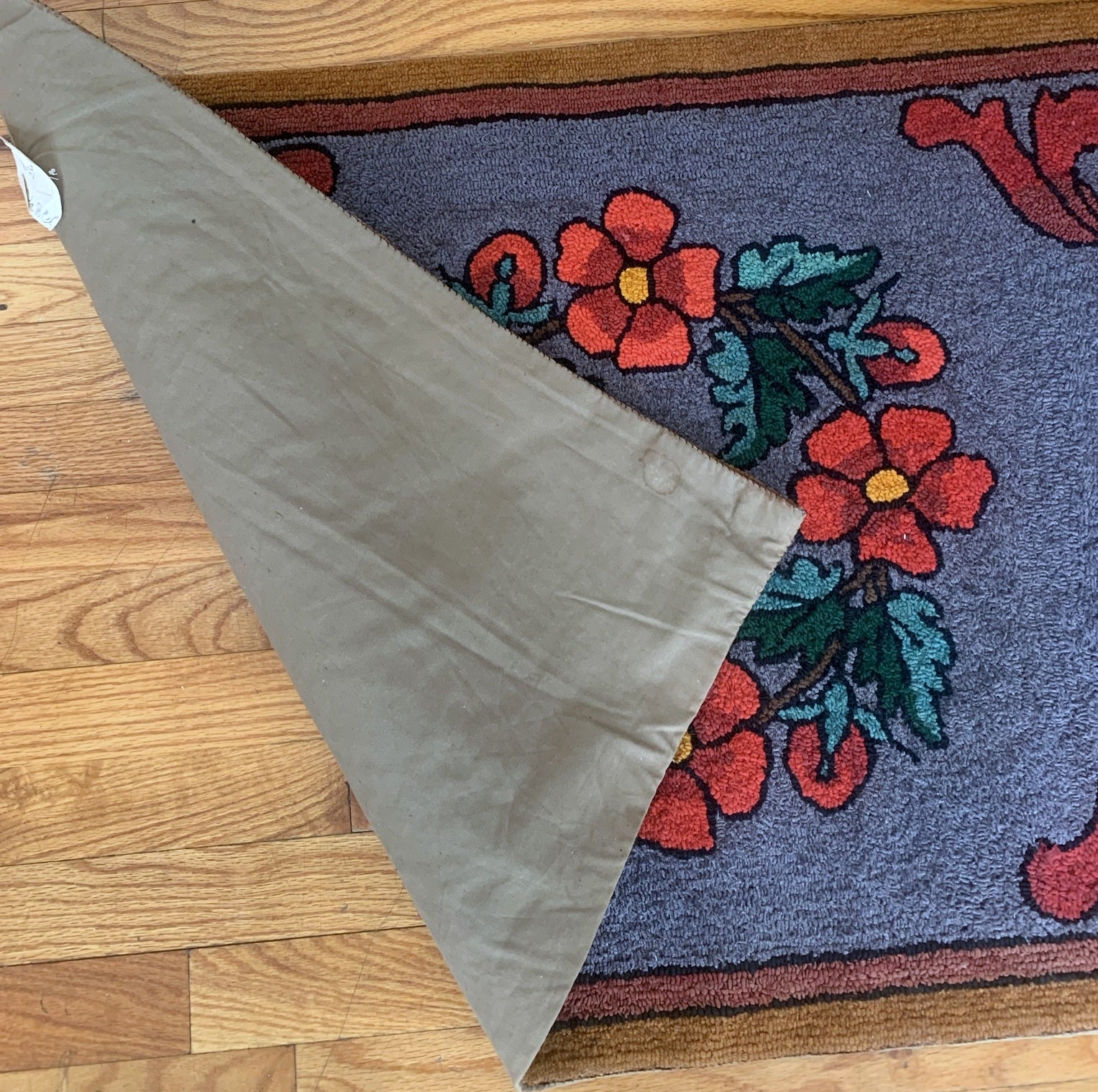 Detailed view of the rug's vibrant purple, red, brown, and green colors